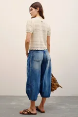 Jean de tiro medio-alto y calce holgado, con piernas anchas que se estrechan hacia el tobillo y largo midi. Confeccionado en denim rígido con lavado bleach y cierre frontal con botones.