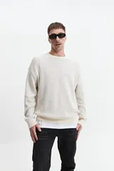 Buzo de punto oversize color negro, con escote redondo y puños.