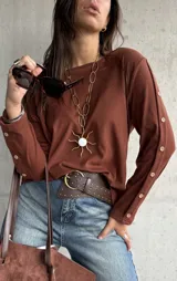 Remera de lanilla color chocolate, de corte recto y manga larga. Presenta una abertura lateral en las mangas decorada con una hilera de botones a tono.