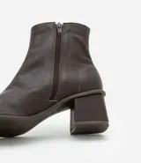 Bota de cuero de caña media para mujer, con punta cuadrada y tacón bloque de 6 cm. Presenta un cierre de cremallera en el lateral interno y una costura central decorativa en la parte frontal.