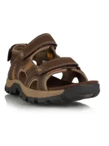 Sandalia de hombre Caterpillar modelo Giles, color marrón, con diseño de tiras ajustables con velcro, confeccionada en PU Nubuck y canvas, con forro de malla y suela de goma resistente.