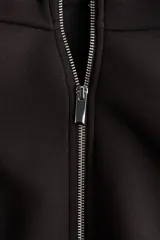 Campera efecto neopreno color negro, con cuello chimenea, cierre frontal completo, hombros caídos y diseño fruncido en el bajo.