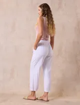 Pantalón color beige, marca Dash, de corte cropped y pretina trasera elastizada. Presenta bolsillos delanteros y traseros.
