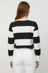 Buzo de cuello redondo y manga larga con diseño de rayas horizontales anchas en tonos bordó y rosado claro.