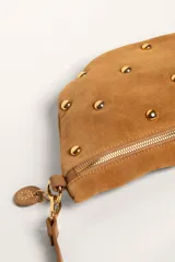 Bandolera de gamuza color marrón con diseño de media luna, decorada con tachas metálicas doradas distribuidas en el frente. Cuenta con cierre superior metálico y correa larga ajustable para llevar cruzada.