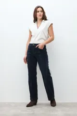 Pantalón de jean oscuro de tiro alto, corte recto y pierna ancha, con costuras verticales marcadas en el frente.