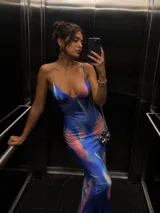 Vestido largo de satén con estampado abstracto en tonos azules y rosados, de corte ajustado, escote en V profundo y breteles finos.