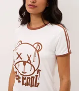Pijama corto Lov de dos piezas confeccionado en peach touch. Compuesto por remera blanca de manga corta con ribetes y cuello marrón, con estampa frontal de oso y la leyenda "Be Cool", y short de rayas verticales rosadas y blancas con cintura elastizada.