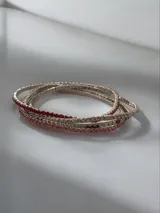 Set de pulseras elásticas compuestas por hileras de strass en tonos rojo, plateado y rosado.