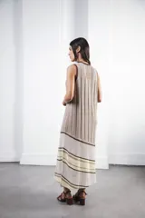 Vestido midi tejido en punto canalé negro con detalles en lurex plateado. Presenta calado artesanal en el ruedo, abertura lateral y etiqueta de cuero en la parte trasera del cuello.