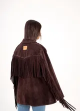Blazer de gamuza color chocolate, con diseño de flecos largos en la parte posterior de las mangas y espalda. Presenta cierre frontal con botones y solapas clásicas.