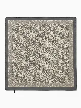 Pañuelo cuadrado con estampado paisley en tonos gris y beige, con borde liso en color gris oscuro.