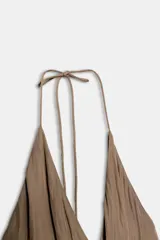 Top de escote en pico cruzado con tirantes finos ajustables y bajo asimétrico con caída fluida.