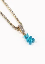 Collar dorado con cadena de eslabones y dije de oso de gomita color celeste.