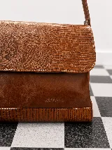Cartera de hombro Sagali modelo Pianosa, confeccionada 100% en cuero vacuno negro con detalles texturizados símil reptil en la solapa y base, y costuras en contraste. Cuenta con correa ajustable.