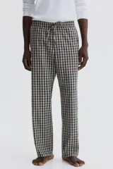 Pantalón de corte relajado confeccionado en popelina de algodón con estampado de cuadros. Presenta cintura elástica con cordón de ajuste y bolsillos laterales.