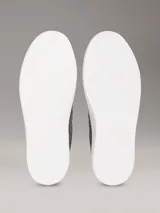Zapatillas negras de piel sintética con monograma de Calvin Klein grabado en relieve, suela de goma blanca y cordones al tono.