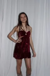 Vestido corto azul metalizado con diseño cut-out, argolla central en el busto, tirantes halter y falda con volado en el ruedo.