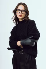 Sweater tejido negro de silueta relajada, con cuello alto y textura trenzada.
