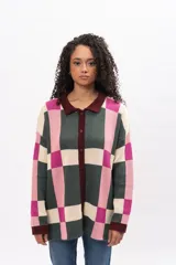 Saco largo de punto con diseño geométrico de cuadros en tonos verde, rosa y crema. Presenta cuello tipo polo, cierre frontal con botones y puños en color bordó.