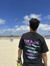 Remera color crema de algodón con estampa en la espalda de un paisaje playero con el texto "Chema Sure Chate et la mer".