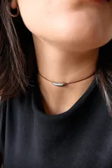 Gargantilla con tiento de hilo encerado bordó y dije tubular curvo de acero quirúrgico.
