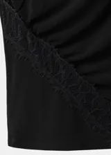 Top negro sin mangas de cuello redondo, con diseño drapeado en el delantero y detalles de encaje en el hombro y lateral.