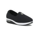 Zapato casual tipo slip-on de lycra color negro, con suela de plataforma blanca y cámara de aire en el talón. Presenta un aplique circular metálico con logo en el empeine.