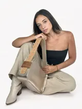 Cartera baguette dorada de cuero genuino, con asa reversible.