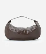 Cartera modelo hobo de gran tamaño, confeccionada en poliuretano con acabado brillante y textura suave. Presenta un diseño de media luna con asa ancha integrada para llevar al hombro y cierre superior.
