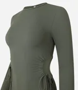 Vestido ajustado de largo midi, color verde militar, con cuello redondo y mangas largas. Presenta aberturas laterales en la cintura ajustadas con lazos.