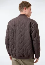 Campera bomber reversible, de diseño acolchado con costuras romboidales, cierre frontal completo y bolsillos laterales.