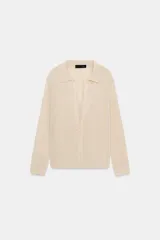 Chaqueta de punto de cuello polo y manga larga con cierre frontal de botones. Incluye un top interior a juego de escote redondo y tirantes finos.
