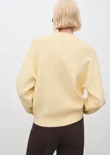 Jersey de punto medio color amarillo, con cuello perkins, manga larga y diseño recto.