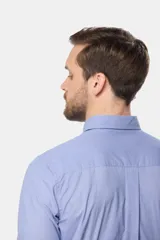 Camisa sport a cuadros de manga larga, en tonos celestes y blancos, con cuello abotonado, bolsillo en el pecho y logo bordado.