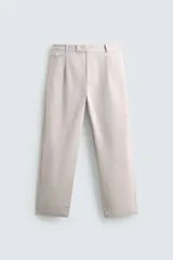 Pantalón de corte relajado confeccionado en tejido de algodón con estructura twill. Presenta pliegues frontales, bolsillos laterales y bolsillos traseros de doble vivo con botón. Cierre frontal con cremallera y botón.