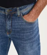 Pantalón de jean azul de corte slim, con bolsillos delanteros y traseros.
