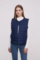 Chaleco azul marino con cierre de botones a presión, cuello redondo y bolsillos laterales. Diseño acolchado.