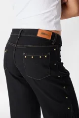 Pantalón de pierna ancha con acabado brillante, confeccionado en lino. Presenta un diseño de tiro medio con cierre de botón y cremallera, bolsillos traseros y etiqueta de marca en la cintura.