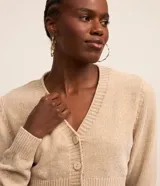 Cardigan cropped color beige, con escote en pico, abotonado delantero y mangas largas.