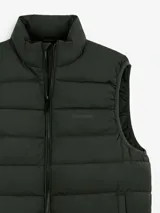 Chaleco acolchado de color azul marino, con cierre frontal completo y cuello alto. Presenta un diseño de costuras horizontales y logo bordado en el pecho.