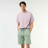 Bermuda verde de felpa ligera, de corte recto y holgado, con cintura elástica ajustable mediante cordón.