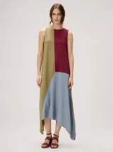 Vestido midi de lino con diseño geométrico en bloques de color negro, marrón y beige, cuello redondo, sin mangas y dobladillo asimétrico en punta.