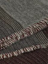 Bufanda de diseño clásico con flecos finos y cortos, en tonos de gris oscuro y gris claro.