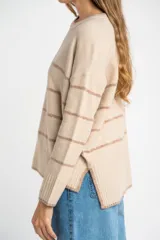 Sweater color crema con rayas horizontales en tonos marrón, bordeaux y beige.