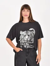 Remera de algodón color marrón con efecto lavado, de corte holgado y manga corta. Presenta un estampado frontal con temática espacial que incluye planetas, estrellas y la frase 'Into the cosmos'.