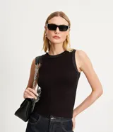 Top sin mangas negro, ajustado al cuerpo, con cuello redondo y sisas ribeteadas en satén negro.