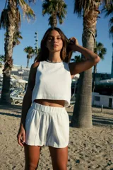 Short blanco de lino y rayón con cintura elástica y bolsillos laterales.