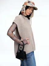 Chaleco de tejido de punto con lana y alpaca, de corte relajado y caída recta. Presenta laterales abiertos con cierre de botones y cuello redondo.