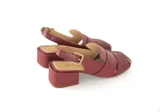 Sandalia de cuero color bordó con diseño de tiras anchas entrecruzadas, punta cuadrada y talón descubierto con pulsera ajustable. Cuenta con taco ancho medio forrado en cuero.